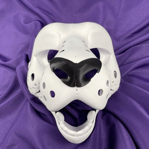 May include: White furry mask with black nose and open mouth. The mask has a textured surface and is designed to look like an animal.