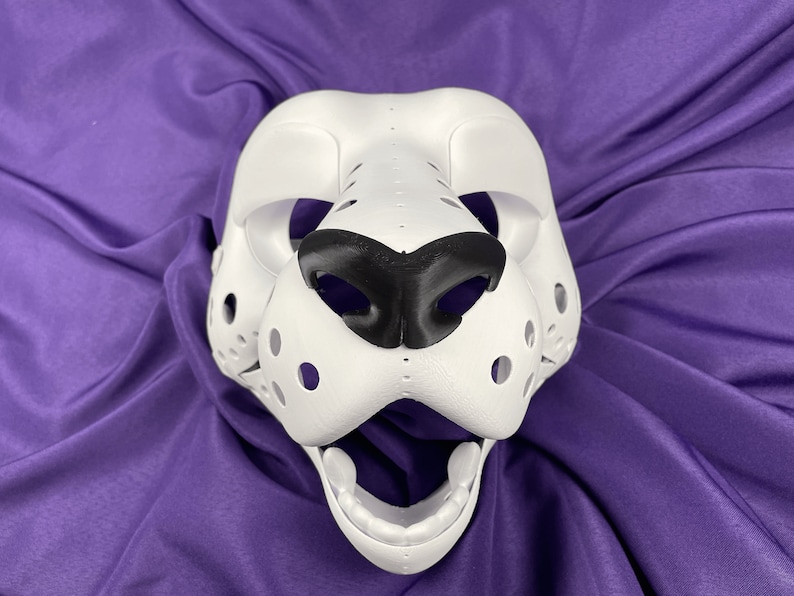 May include: White furry mask with black nose and open mouth. The mask has a textured surface and is designed to look like an animal.