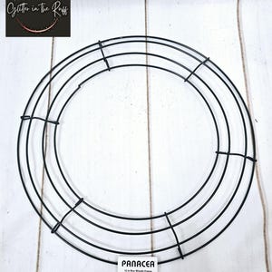 Może przedstawiać: Czarna metalowa rama do wianka o średnicy 30,5 cm. Rama wykonana jest z drutu i ma okrągły kształt. Rama jest przeznaczona do rękodzieła i dekoracji.