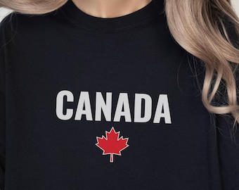 May include: A black t-shirt with the word "CANADA" printed in white and a red maple leaf underneath.