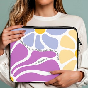 May include: A laptop sleeve with a colorful abstract floral design. The text "SUFFICIENT FOR YOU, FOR MY POWER IS MADE PERFECT IN WEAKNESS. 2 CORINTHIANS 12:9" is printed on the sleeve.