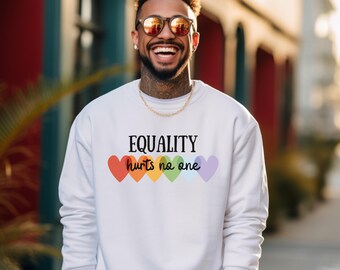 Può includere: Felpa bianca con il testo "EQUALITY hurts no one" e una fila di cuori arcobaleno.