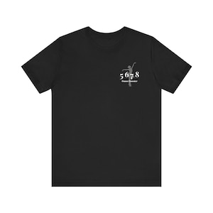 May include: Black t-shirt with a white graphic of a dancer and the text "5678 Dance Booster".