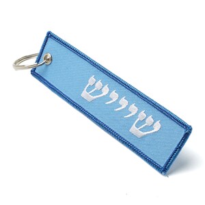 May include: A light blue key chain with a white Hebrew inscription. The inscription is the Hebrew word for "Chai", which means "life".