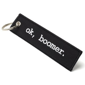 May include: Black key chain with a white embroidered phrase "ok, boomer."