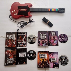 May include: A set of Guitar Hero video games and guitar controller for the Playstation 2 console. The set includes Guitar Hero, Guitar Hero II, Guitar Hero Encore: Rocks the 80s, and Guitar Hero III: Legends of Rock. The guitar controller is red and black with a strap.