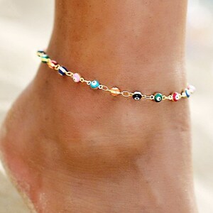 May include: A gold anklet with a chain and small colorful evil eye beads.