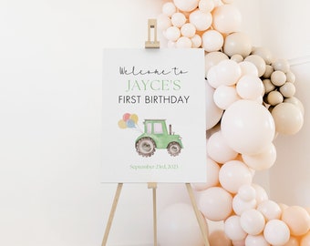 Könnte beinhalten: Willkommen zu Jayces erstem Geburtstagsschild mit einem grünen Traktor und Ballons. Das Schild steht auf einem Holzstaffelei und ist von beigefarbenen Ballons umgeben.