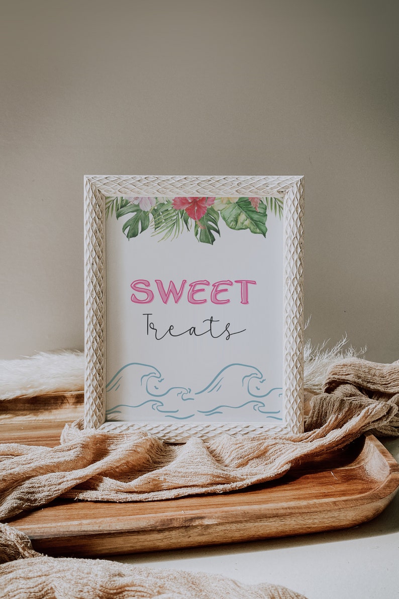 May include: White framed sign with a tropical floral border and blue waves at the bottom. The sign says "SWEET treats" in pink and black lettering.