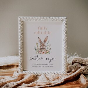 May include: A framed sign featuring a watercolour illustration of a rabbit surrounded by flowers. The sign says "fully editable" at the top and "custom sign" in script below the rabbit. The frame is white with a textured pattern.