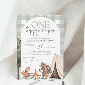 Op de afbeelding: Een groene en witte ruitjespatroon uitnodiging met een witte cirkel en de tekst "ONE happy camper" in groene schrijfletters. De uitnodiging is voor Jayce's eerste verjaardag en bevat de datum, tijd en locatie van het feest. De uitnodiging bevat ook een aquarel illustratie van een vos en een beer die kamperen.