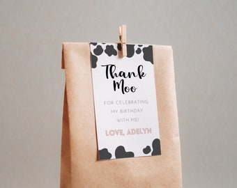 May include: A white thank you tag with black cow print border. The text reads "Thank Moo" in black script font. Below the text is "For celebrating my birthday with me! Love, Adelyn" in black font.