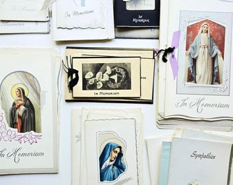 Op de afbeelding: Een verzameling vintage herdenkingskaarten met religieuze afbeeldingen, waaronder afbeeldingen van de Maagd Maria, bloemenillustraties en zwart-witfotografie. Elke kaart bevat de tekst In Memoriam of Sympathies.