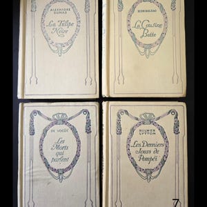 May include: Four antique books with cream covers. Each book has a decorative oval design and French text. Titles include "La Tulipe Noire," "La Cousine Bette," "Les Morts qui parlent," and "Les Derniers Jours de Pomp&eacute;i."