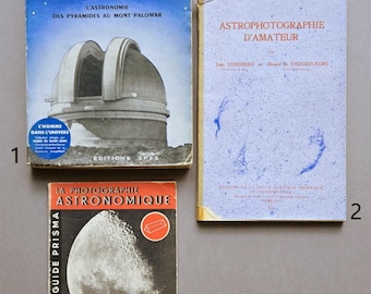 Op de afbeelding: Drie vintage boeken over astronomie. Het boek linksboven is blauw met een afbeelding van een observatoriumkoepel en de tekst L'Esprit de l'Homme. Het rechterboek is lichtblauw met de titel Astrophotographie d'Amateur. Het onderste boek toont de maan.