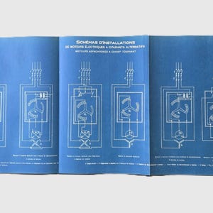 Peut inclure: Livre ouvert avec des pages bleues présentant des schémas blancs de circuits électriques. Le texte en haut indique "SCHÉMAS D'INSTALLATIONS DE MOTEURS ÉLECTRIQUES À COURANTS ALTERNATIFS MOTEURS ASYNCHRONES À CHAMP TOURNANT."