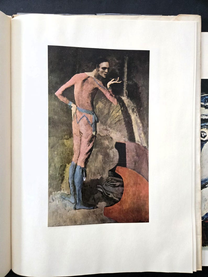 May include: A printed reproduction of a painting featuring a figure in a pink bodysuit with blue leggings and a blue waist sash. The figure stands in a dark, shadowed environment, gesturing with one hand while looking toward the right side.