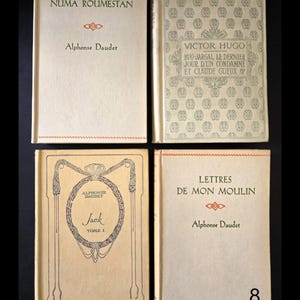 May include: Four vintage books with cream covers are shown. The titles and authors are visible, including "NUMA ROUMESTAN" by Alphonse Daudet, and "BUG-JARGAL, LE DERNIER JOUR D'UN CONDAMN&Eacute; ET CLAUDE GUEUX" by Victor Hugo.