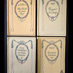 May include: Four vintage books with cream covers. Each book has Art Nouveau designs in blue and purple, with titles and author names in elegant fonts. The titles include "Mon Oncle et mon Cur&eacute;" and "Fran&ccedil;ois Le Champi". The number 6 is visible on one book.