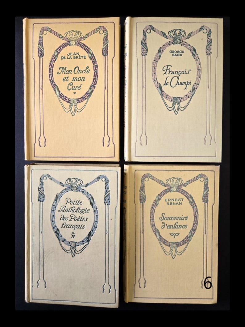 May include: Four vintage books with cream covers. Each book has Art Nouveau designs in blue and purple, with titles and author names in elegant fonts. The titles include "Mon Oncle et mon Cur&eacute;" and "Fran&ccedil;ois Le Champi". The number 6 is visible on one book.