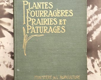 Op de afbeelding: Een saliegroen hardcover boek met goudkleurige tekst in reliëf met de tekst "PLANTES FOURRAGÈRES PRAIRIES ET PÂTURAGES" en "MINISTÈRE DE L'AGRICULTURE CANADA" op de voorkant, voorzien van een gestileerde gouden lijntekening van een plant.