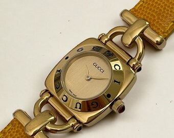 Vintage Gucci Uhr – Horsebit 6300L, gelb-orangefarbenes Lederarmband, goldenes Zifferblatt