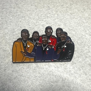 Peut inclure: Épingle en émail représentant un groupe de six hommes en costume, chacun avec un code couleur unique. Les costumes sont dans des tons or, rouge, marine et noir. Chaque homme porte un collier avec une croix. L'épingle a une finition brillante.