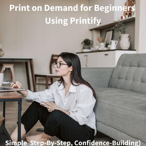 Può includere: Una donna con gli occhiali e una camicia bianca è seduta sul pavimento vicino a un divano grigio, che lavora su un computer portatile. Il testo "MINI COURSE SCRIPT Print on Demand for Beginners Using Printify" è visualizzato nella parte superiore dell'immagine.