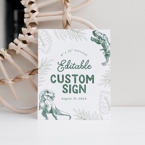 May include: Editable custom sign with a green dinosaur illustration and leafy foliage. The sign is 8 inches by 10 inches and is vertical. The text on the sign reads "Editable Custom Sign" and "August 15, 20XX".