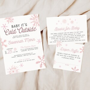 Op de afbeelding: Een roze en witte babyshower-uitnodiging met een sneeuwvlokkenontwerp. De uitnodiging luidt "Baby it's Cold Outside" en bevat de datum, tijd en locatie van de babyshower. De uitnodiging bevat ook informatie over het register en RSVP-details.