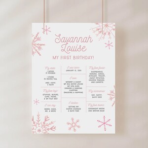 Op de afbeelding: Een roze en witte printbare eerste verjaardagposter met sneeuwvlokken. De poster bevat de naam Savannah Louise en details over het eerste jaar van het kind, waaronder gewicht, lengte, favoriete eten, speelgoed en boeken.
