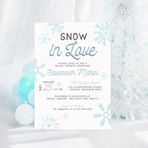Op de afbeelding: Een witte bruidsdoucheinvitatie met blauwe sneeuwvlokken en de tekst "SNOW in Love" voor Savannah Marin. De uitnodiging bevat de datum, tijd en locatie van de douche, evenals de registratie-informatie.