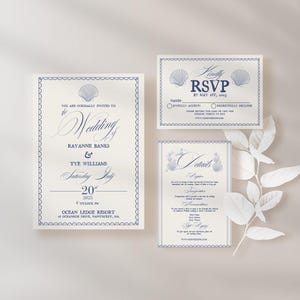 Może przedstawiać: Zestaw trzech kości słoniowej zaproszeń ślubnych z niebieskimi akcentami. Główna karta zawiera wzór muszli i tekst "You are cordially invited to the wedding of Rayanne Banks & Tye Williams Saturday, July 20th, 2025 4 o'clock PM Ocean Ledge Resort at Oceanside Drive, Nantucket, MA". Druga karta zawiera tekst "Kindly RSVP by May 1st, 2025" i dwie muszle. Trzecia karta zawiera tekst "Details" i wzór muszli.