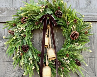 Rustic norfolk pine wreath for front door, cascading cedar Christmas wreath with brass bells and pinecones, winter greenery velvet brown bow