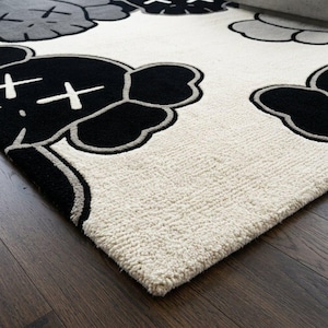 Detailed macro shot of a greyscale pop art character rug highlighting the thick, plush hand-tufted wool fibers, clean scissor-carving outlines, and contrasting black, grey, and cream textures by Crafted Treads Rugs.