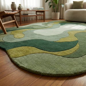 May include: A green area rug with an abstract, flowing design. The rug features shades of green, from light to dark, creating a layered, organic pattern. The rug is on a hardwood floor.