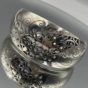 May include: A set of three ceramic mugs with a speckled, matte finish in cream, light grey, and dark grey. Each mug has a simple, minimalist design, suitable for coffee or tea.