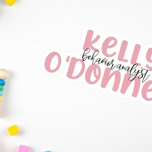 May include: Pink sticker with the text "Kelly O'Donnell behavior analyst" in a white background.