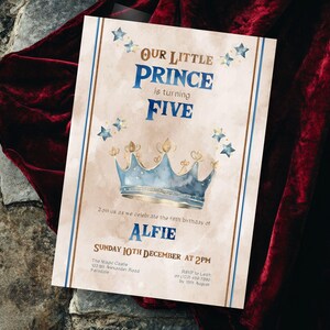 May include: A light brown invitation with blue and gold accents. The invitation reads "Our Little Prince is turning Five" and features a blue and gold crown with stars. The invitation is for a birthday party for Alfie on Sunday, 10th December at 2pm.