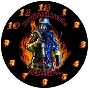 Puede incluir: Una esfera de reloj redonda y negra con un bombero con equipo de protección, sobre un fondo de llamas. Los números del reloj son de color naranja, con el nombre "Manfred" y el texto "Hauptlöschmeister" mostrados.