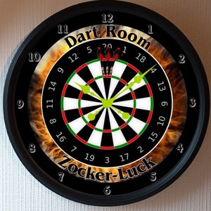 May include: A black clock with a dartboard design. The clock face has a black and white dartboard with red and green rings. The clock face also has a flame design around the dartboard. The clock face has the text "Dart Room" and "Zocker-Luck" on it. The clock hands are green.