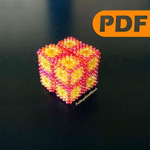 Könnte beinhalten: Würfelförmiger Perlschmuck mit einem Muster aus gelben und roten Perlen. Das Ornament hat ein dreidimensionales Design und ist vor einem dunklen Hintergrund platziert. Das Wort "PDF" befindet sich in einem orangefarbenen Rechteck oben rechts.
