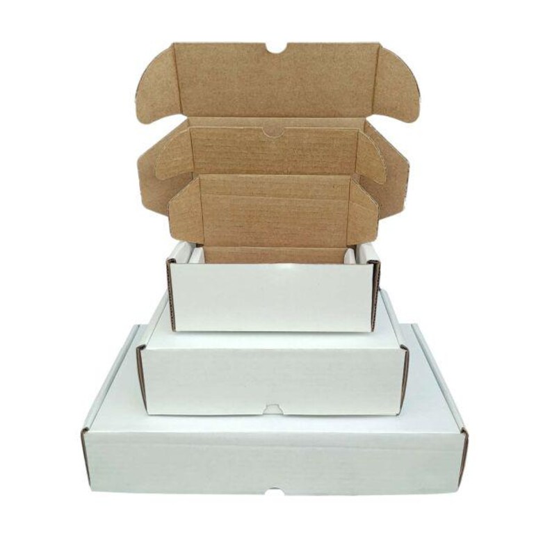 May include: A stack of three rectangular cardboard shipping boxes with white exteriors and natural brown interiors. The boxes are arranged in descending order of size, with the top box open, revealing its internal structure and folding flaps.