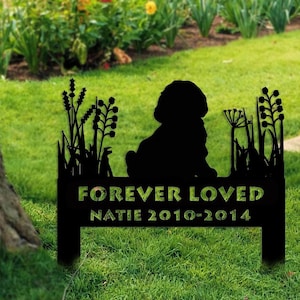 Könnte beinhalten: Schwarze Metallsilhouette eines Hundes, der in einem Grasfeld mit Blumen sitzt. Das Schild lautet "Forever Loved Natie 2010-2014".