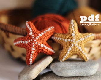 Puede incluir: Dos estrellas de mar de crochet, una naranja y otra amarilla, con detalles blancos. Las estrellas de mar están sobre piedras grises apiladas. El texto "pdf LoopyPattern" está en la esquina superior derecha de la imagen.