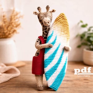 Op de afbeelding: Een gehaakte giraffe in een rode outfit, met een surfboard met blauwe en witte strepen. Het surfboard heeft een gele gradiënt aan de bovenkant. De giraffe is bruin en bruin met een lange nek. De afbeelding heeft de tekst "pdf Crochery".
