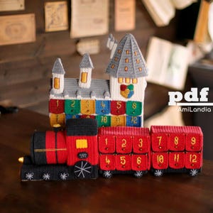 May include: A crochet advent calendar set featuring a castle with numbered compartments and a red and black steam train with numbered cargo cars. The castle has gray towers and colorful squares. The train has gold-stitched numbers 1 through 12.