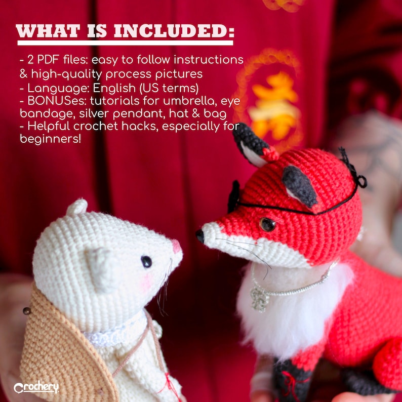 May include: Two crocheted amigurumi toys, a white mouse and a red fox, are facing each other. The mouse is wearing a brown hat and a silver necklace. The fox is wearing a black eye patch and a silver necklace with a charm. The background is a red fabric with Chinese characters.