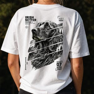 Könnte beinhalten: Ein weißes T-Shirt mit einer schwarz-weißen Grafik eines Irish Setters auf der Rückseite. Das Design enthält den Text IRISH SETTER, DIVISION 07 SETTER LEGACY und Koordinaten. Eine vertikale Linie mit dem Text 68 CM ist ebenfalls zu sehen.