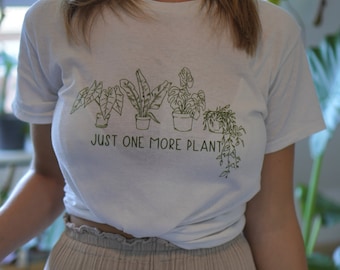 May include: White t-shirt with a green line drawing of five potted plants and the text "Just one more plant".